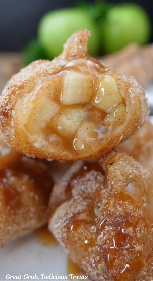 A close up of a fried wonton filled with an diced apple filling.