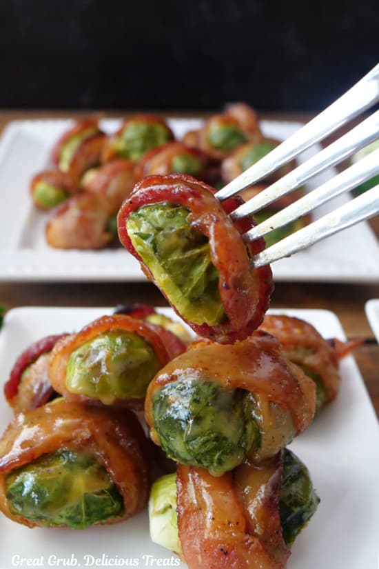 A bacon wrapped brussel sprout on a fork.