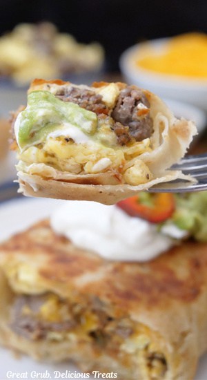 A bite of breakfast burrito on a fork.