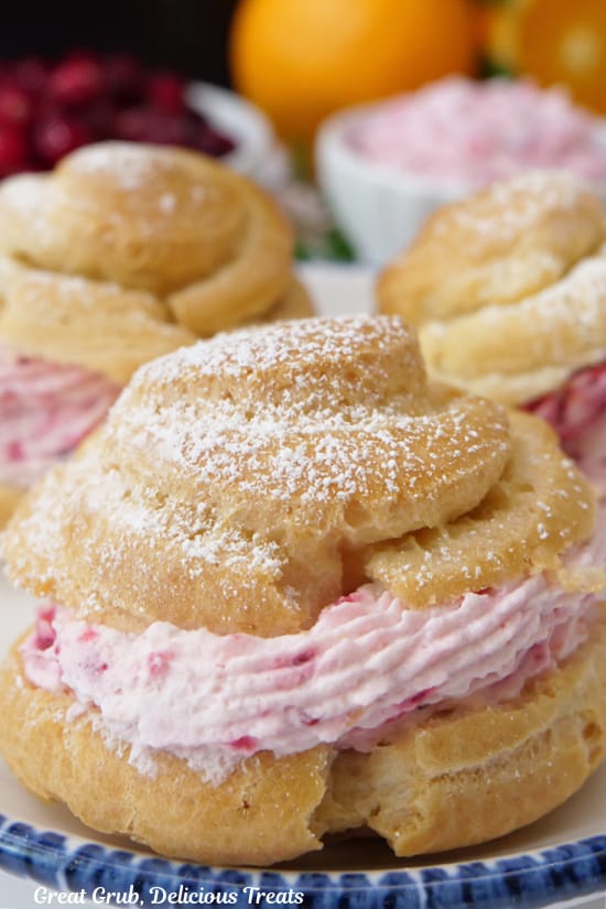 A close up of a cream puff filled with cranberry mousse filling.