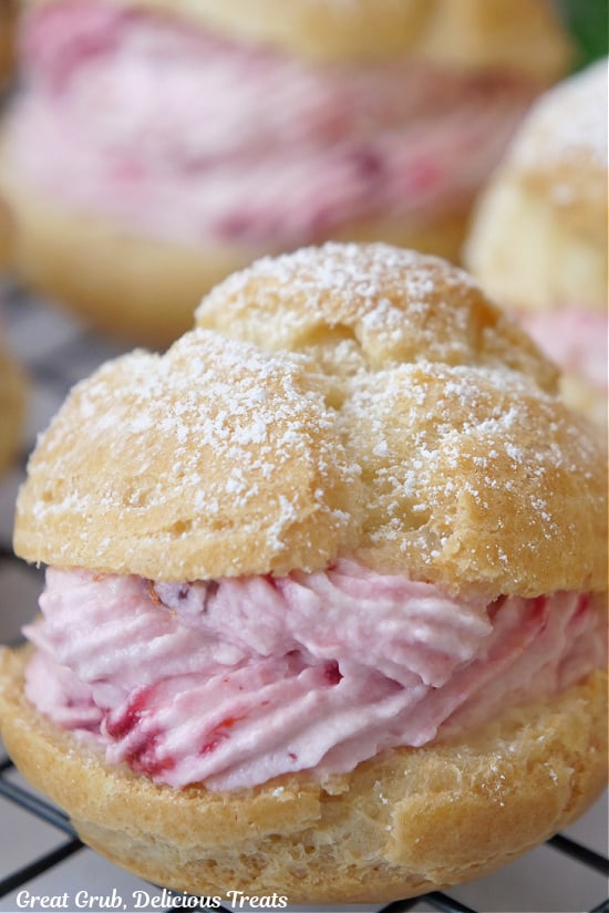 A close up of cream puffs with a cranberry mousse filling.