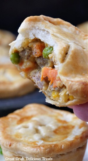 A close up of a mini beef pot pie with a bite taken out of it.