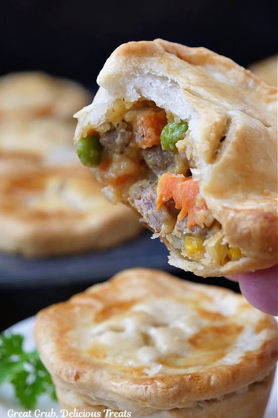 A close up of a mini pot pie with a bite taken out of it.