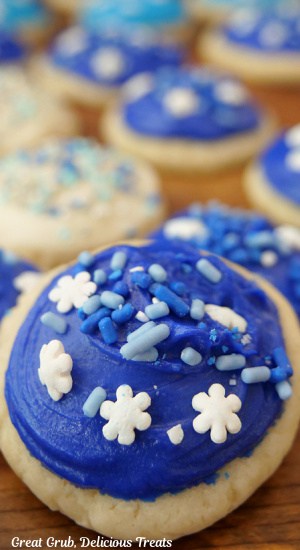 A close up of a blue frosted sugar cookie with candy sprinkles on top.