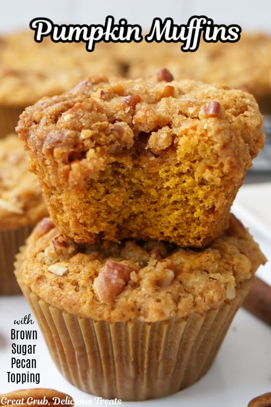 Two pumpkin muffins on top of each other with a bite taken out of the top muffin.