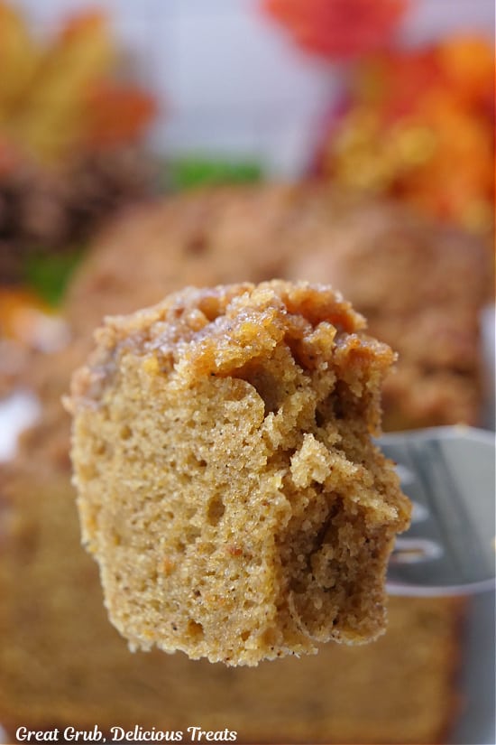 A close up of a bite of butternut squash bread on a fork.