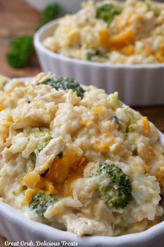 A close up of a serving of chicken broccoli rice casserole in a white oval serving bowl.