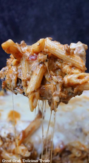 A big spoonful of lasagna pasta being scooped out of the pot.