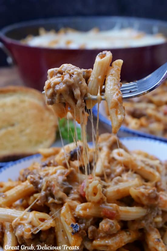 A forkful of cheesy pasta showing the gooey cheese pull.