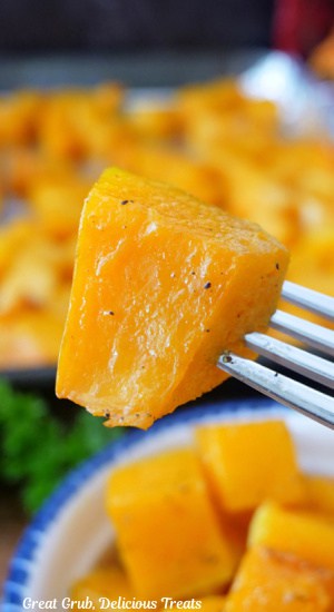 A close up of a bite of roasted butternut squash on a fork.