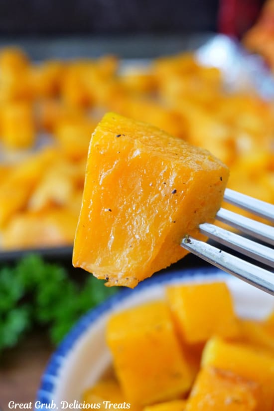 A close up of a bite of butternut squash on a fork.