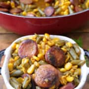 A small square serving bowl filled with a serving of sausage, green beans, and corn.