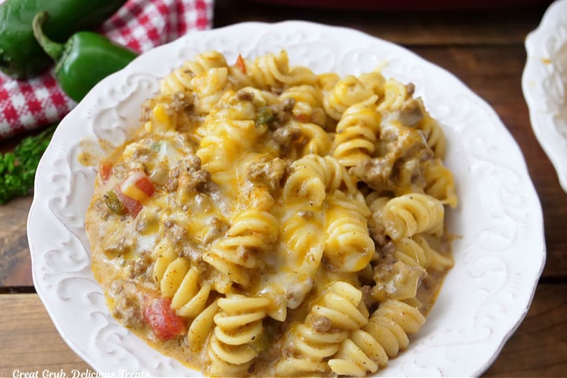 A white bowl filled with ground beef, cheese, rotini pasta, in a creamy sauce.