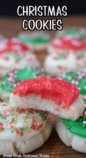 A close up of a mini festive cookie with red, green and white frosting, and a bite taken out of one of the cookies.