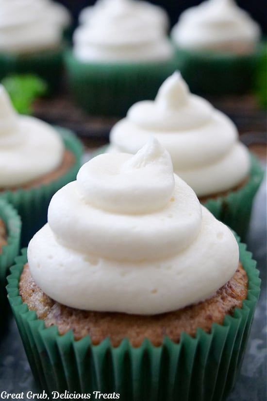 A close up of banana nut muffins with cream cheese frosting.