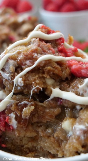 A close up photo of a serving of white chocolate raspberry cinnamon bread pudding.