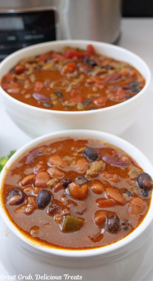 Two white bowls filled with chili.