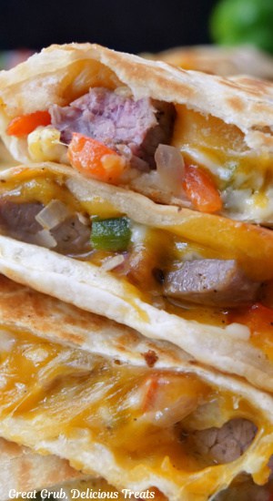 A super close up of a steak quesadilla cut into pieces and stacked on top of each other.