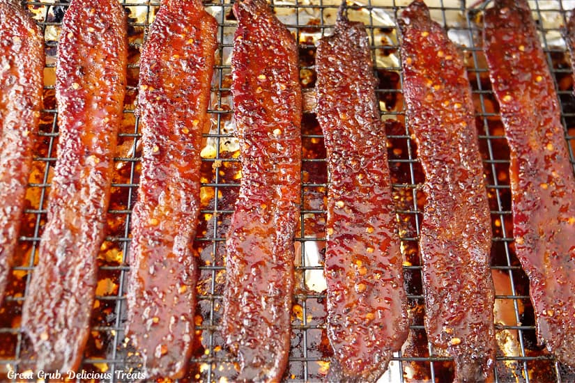 A baking sheet with a wire rack with 8 slices of billionaire bacon on it after being pulled out of the oven.
