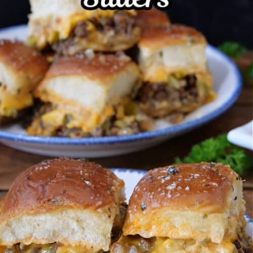 Two cheeseburger sliders on a white plate with blue trim with more sliders in the background.