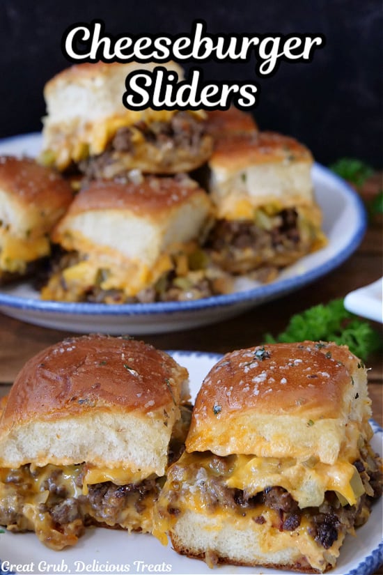 Two cheeseburger sliders on a white plate with blue trim with more sliders in the background.