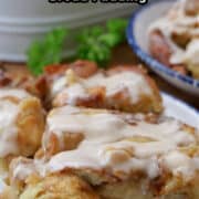 A serving of cinnamon raisin bread pudding on a white plate with blue trim.