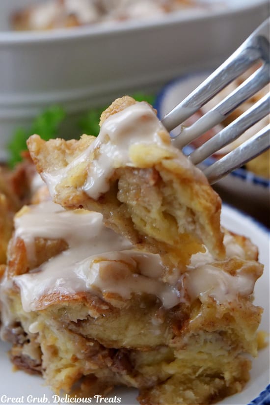 A bite of cinnamon bread pudding on a fork.
