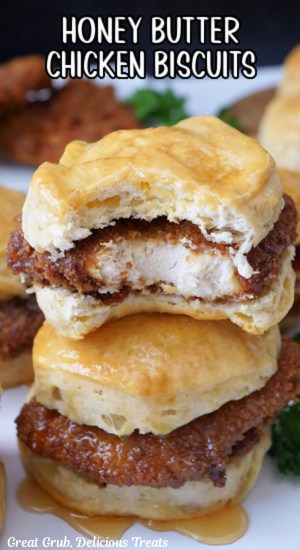 A close up of two chicken biscuits stacked on top of each other with a bite taken out of the top one.