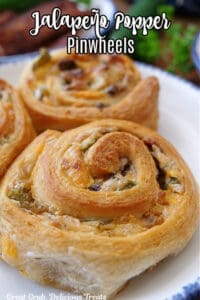 A close up of jalapeno popper pinwheels on a white plate with blue trim.