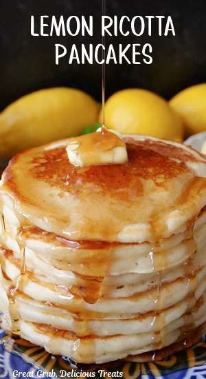 A close up of a stack of lemon pancakes with syrup being drizzled over the top of the pancakes.