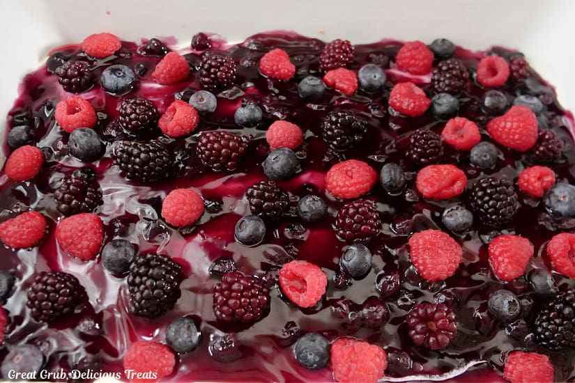 A white baking dish with mixed berry pretzel dessert in it before it was cut and served.