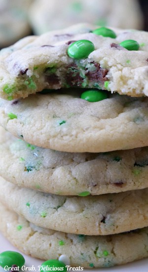 A stack of 5 sugar cookies with a bite taken out of the top cookie.