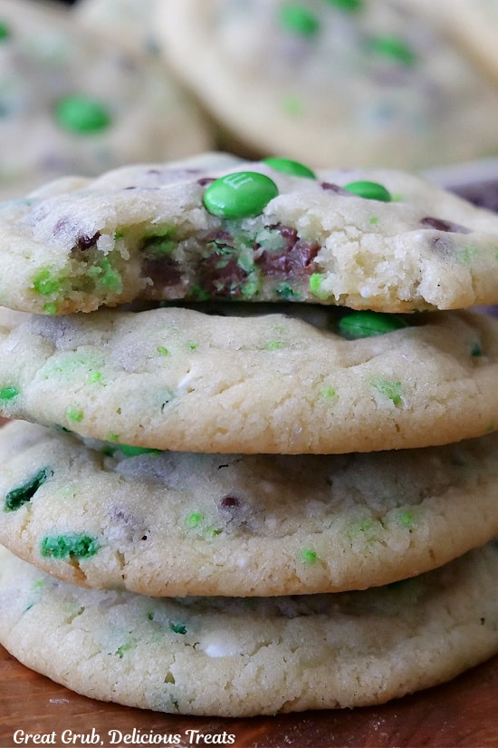 A stack of four sugar cookies with a bite taken out of the top cookie.