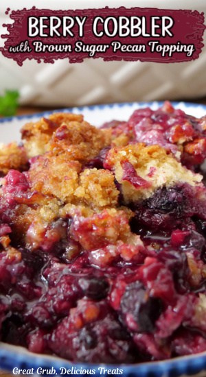 A serving of berry cobbler in a white bowl with blue trim with the title of the recipe at the top of the picture.