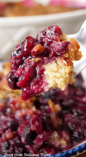 A close up of a spoonful of berry cobbler.