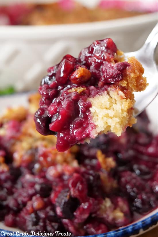 A close up of a spoonful of berry cobbler.