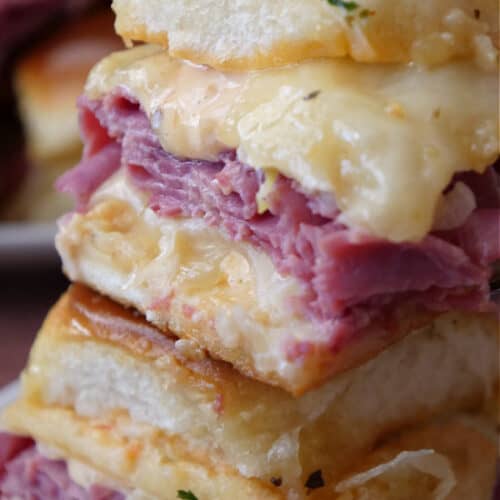 A close up photo of two Reuben sliders with the title of the recipe at the top left corner.