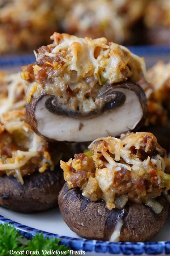 A close up of a few stuffed mushrooms with one cut in half showing the inside ingredients.