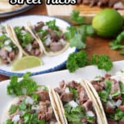 Three street tacos on a white plate with three more tacos in the background.