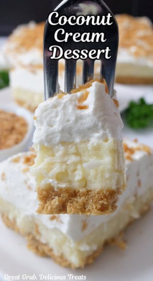 A close up of a bite of coconut cream dessert on a fork.