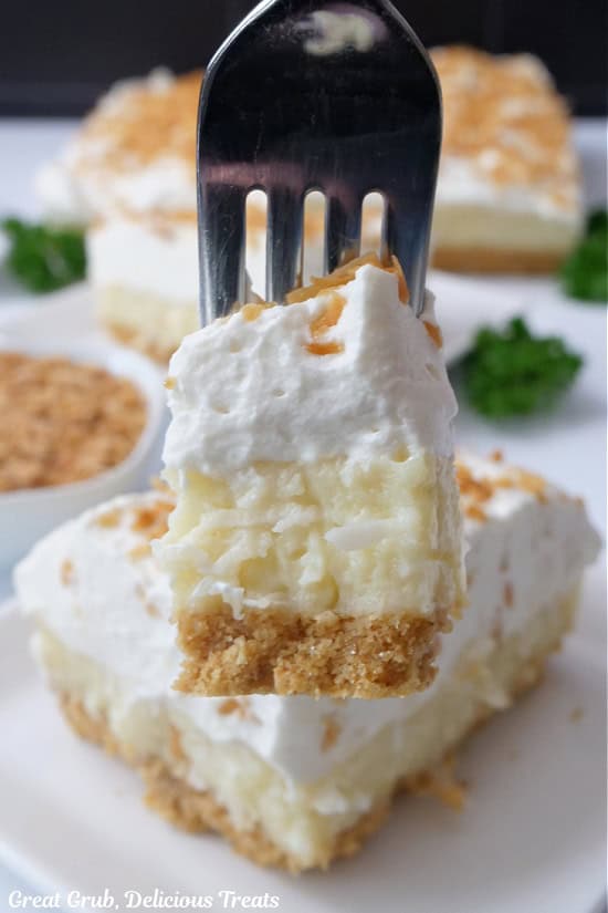 A close up of a bite of coconut dessert on a fork.