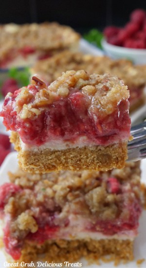 A close up of a bite of raspberry cheesecake on a fork.