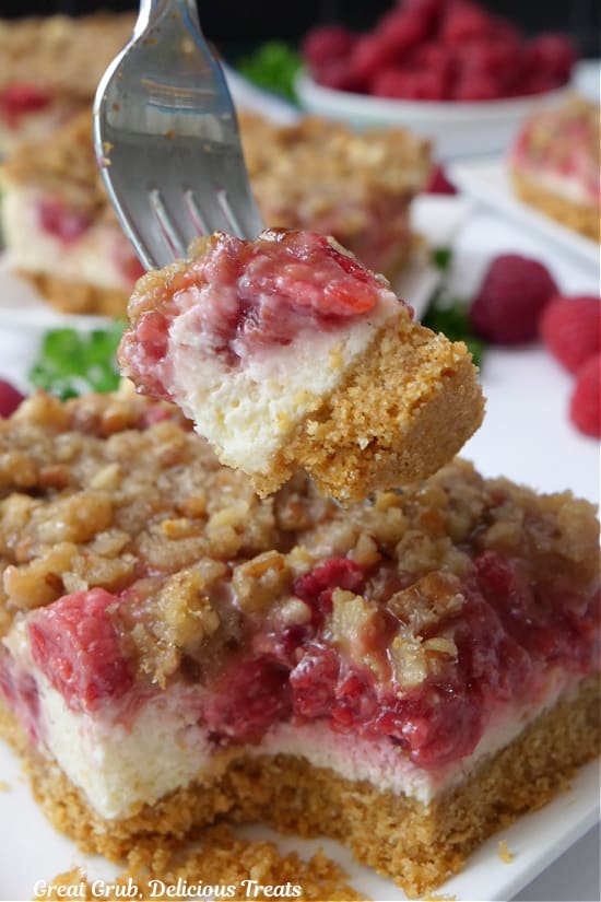 A close up of a bite of cheesecake bars on a fork.