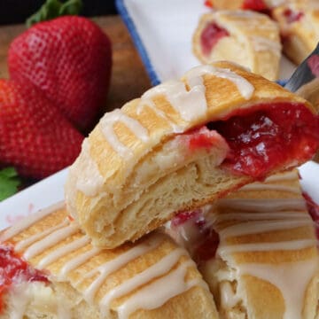 A white plate with three slices of strawberry pastries on it.