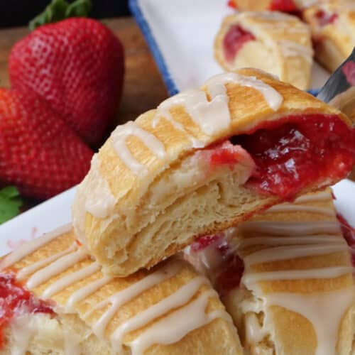 A white plate with three slices of strawberry pastries on it.
