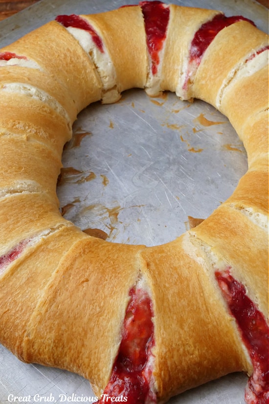 A baking sheet with a strawberry pastry ring on it right after being removed from the oven and before the glaze drizzle is put on.