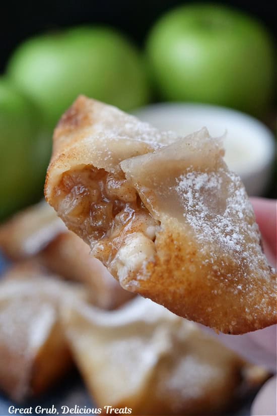 A close up of a fried wonton with a bite taken out of it.