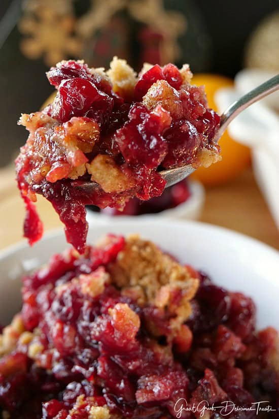 A close up of a spoon filled with cranberry crisp.