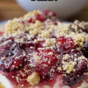 A slice of cherry cream cheese dessert on a white plate.