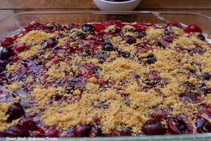 A glass baking dish filled with cherry cream cheese dessert.
